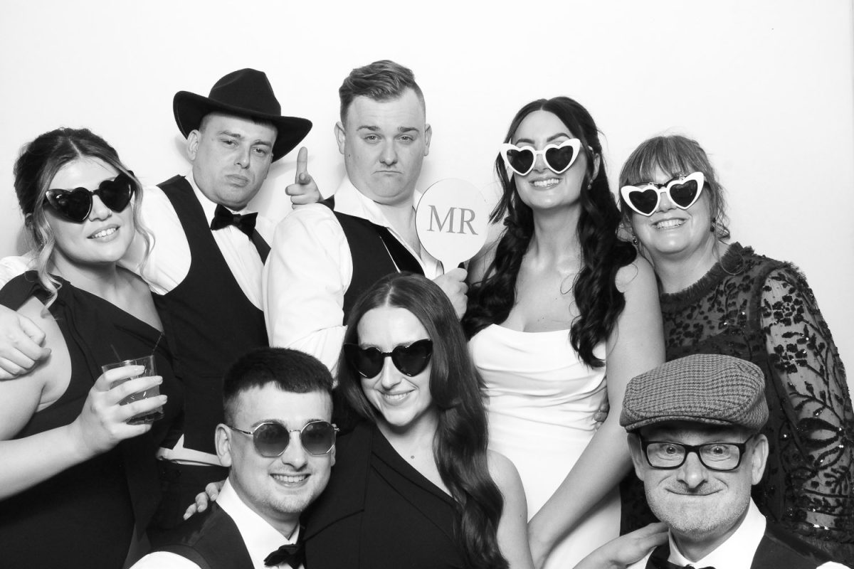 Bridge and groom posing and having fun with props in Middleton Lodge Photo Booth hire